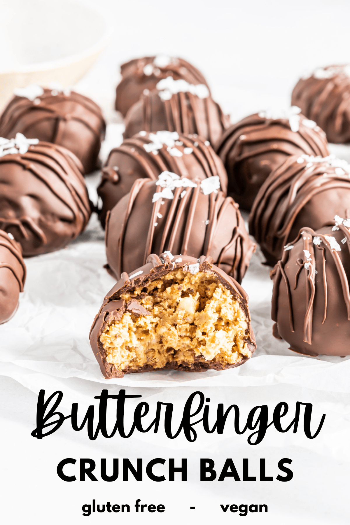 chocolate coated peanut butter crunch balls on white parchment paper; text underneath on white background reads "butterfinger crunch balls, gluten free and vegan"