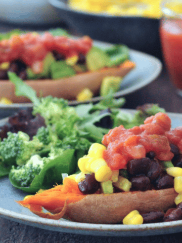 Savory sweet potato boats on plates: black bean, corn, and salsa fillings in bowls in background