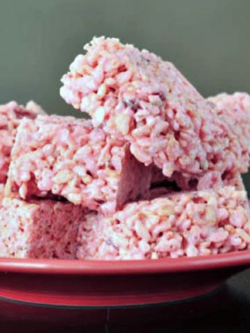light pink colored strawberry lemon rice crispies squares stacked on a plate