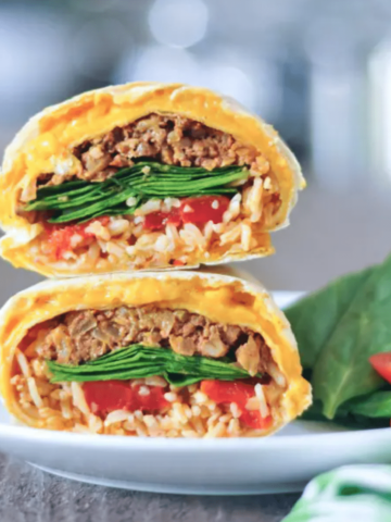 a cheesy quesarito sliced in half and stacked to show insides - rice, beans, spinach, and tomato salsa wrapped in a cheese layer of quesadilla.