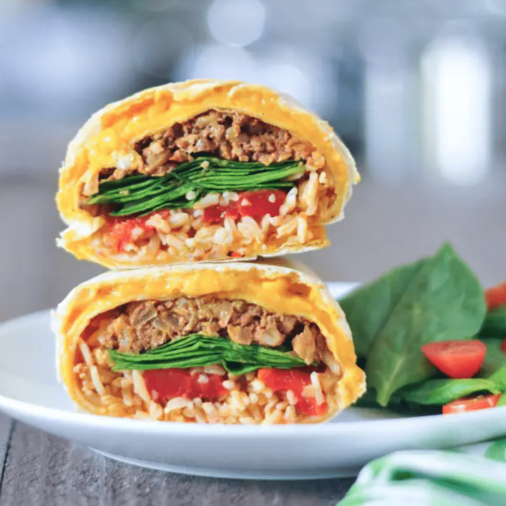 a cheesy quesarito sliced in half and stacked to show insides - rice, beans, spinach, and tomato salsa wrapped in a cheese layer of quesadilla.