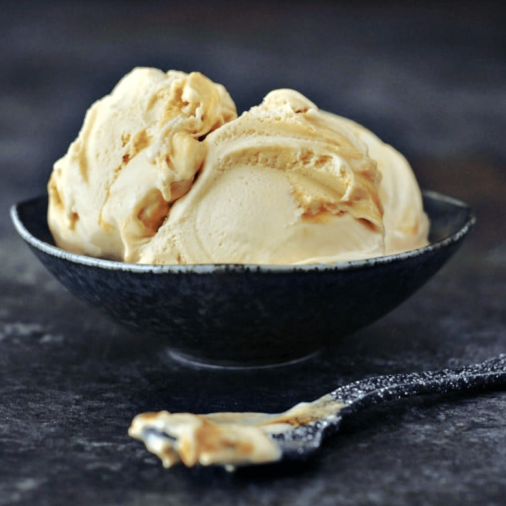 tan colored ginger maple miso ice cream in a bowl, spoon on the side