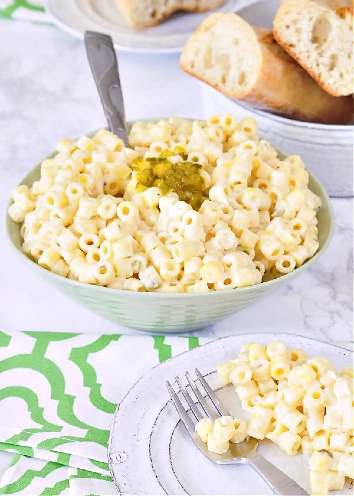 Hawaiian mac salad in a green serving bowl, with a smaller plate of mac salad on the side.