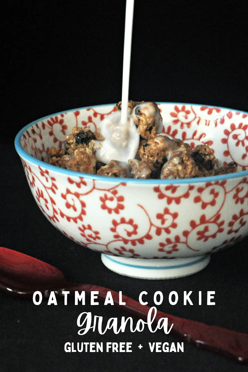 Milk being poured over oatmeal raisin cookie granola in a red and white cereal bowl, a red spoon next to bowl.