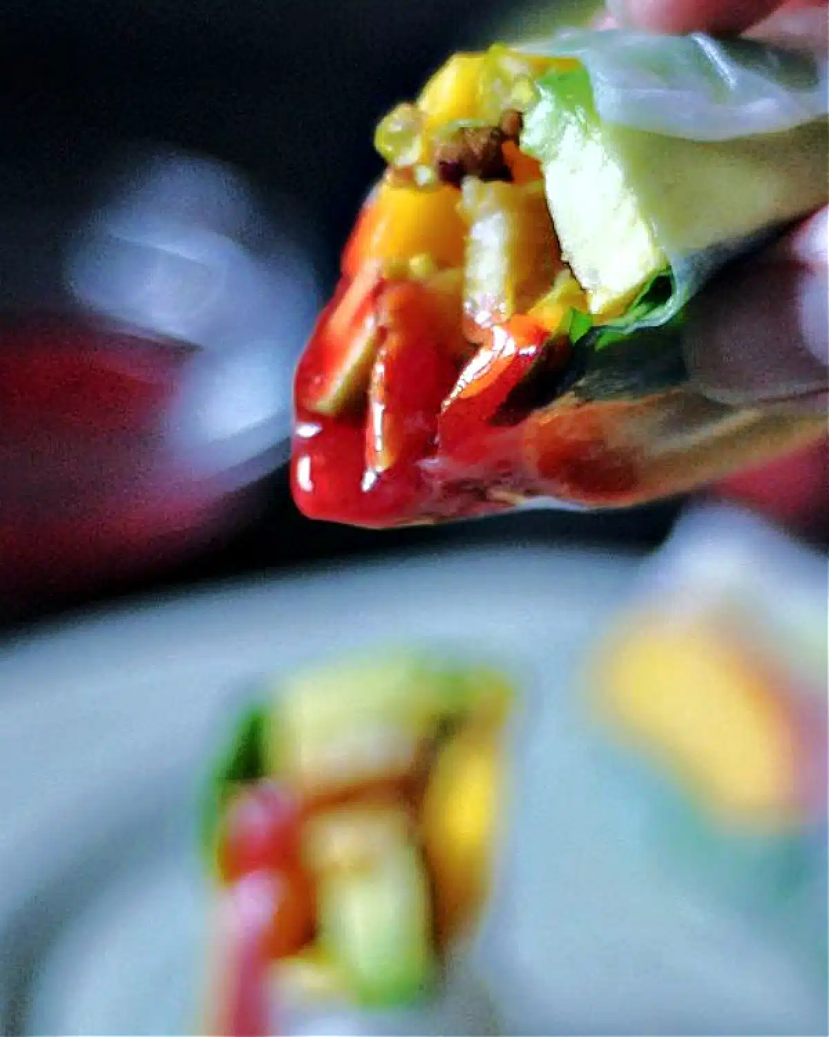 Summer rolls being dipped into reaspberry sauce (summer rolls are pan fried tempeh, sliced nectarines, sliced avocado, fresh basil leaves, and pistachios rolled in softened rice paper).