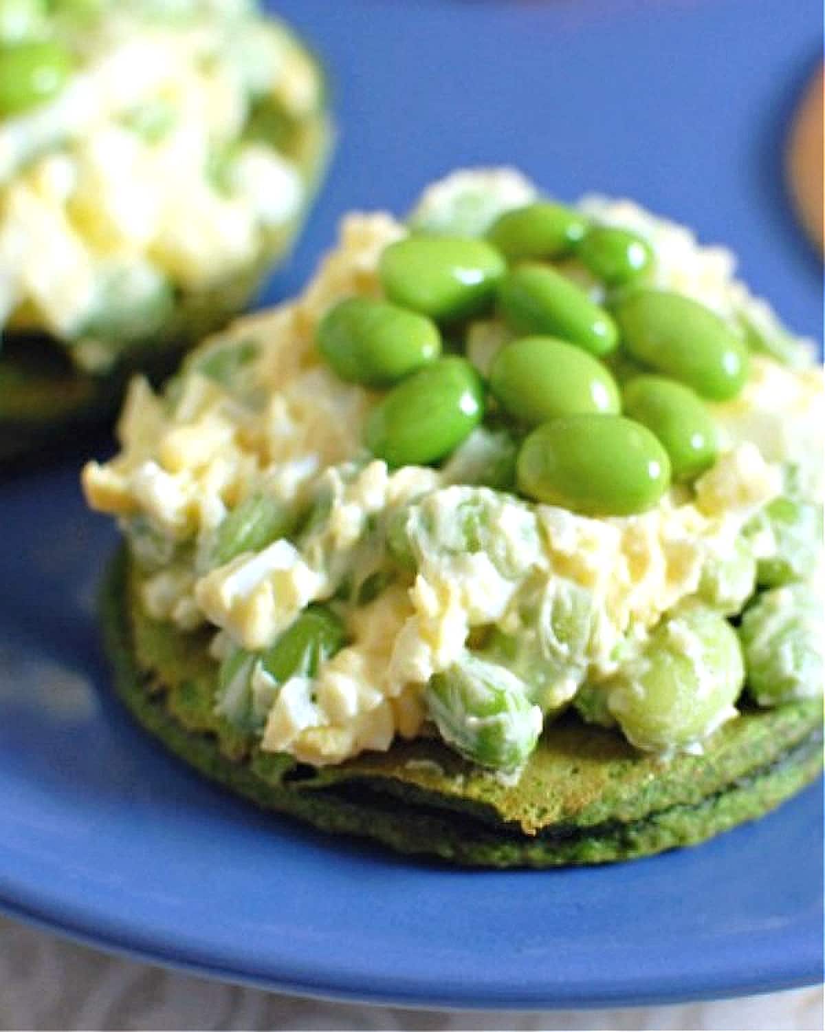 Vegan edamame egg salad on a green spinach pancake.