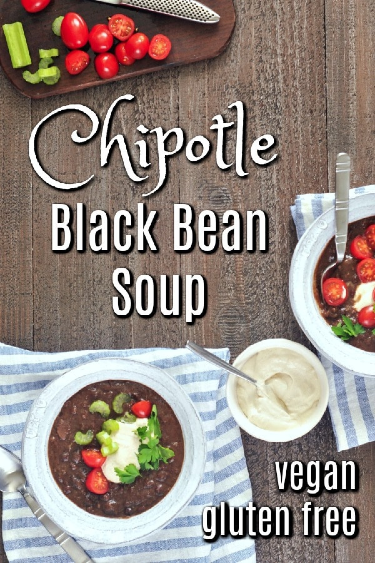 Overhead view of Chipotle Black Bean Soup in bowls, garnished with cherry tomatoes, cashew cream, and green parsley.