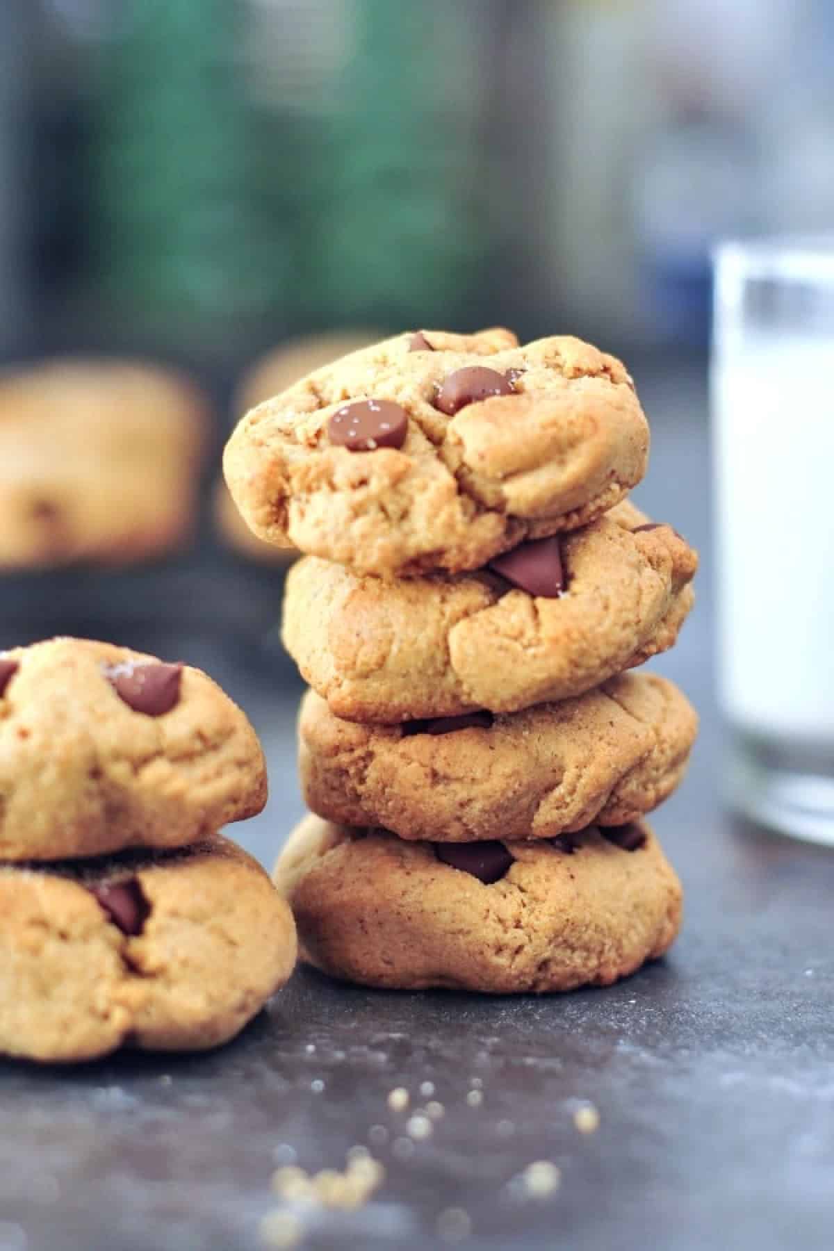 A stack of flourless chocolate chip cookies with a glass of milk.