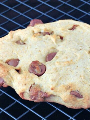 A single serve chocolate chip cookie on a wire cooling rack.