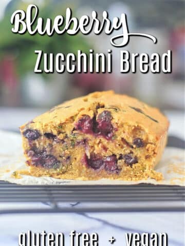 A loaf of blueberry zucchini bread on a wire cooling rack.