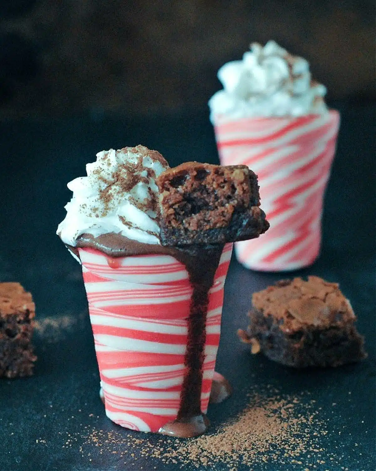 Hot chocolate peppermint shots: hot chocolate in an edible peppermint candy shot glass, topped with whip cream and a small brownie square.