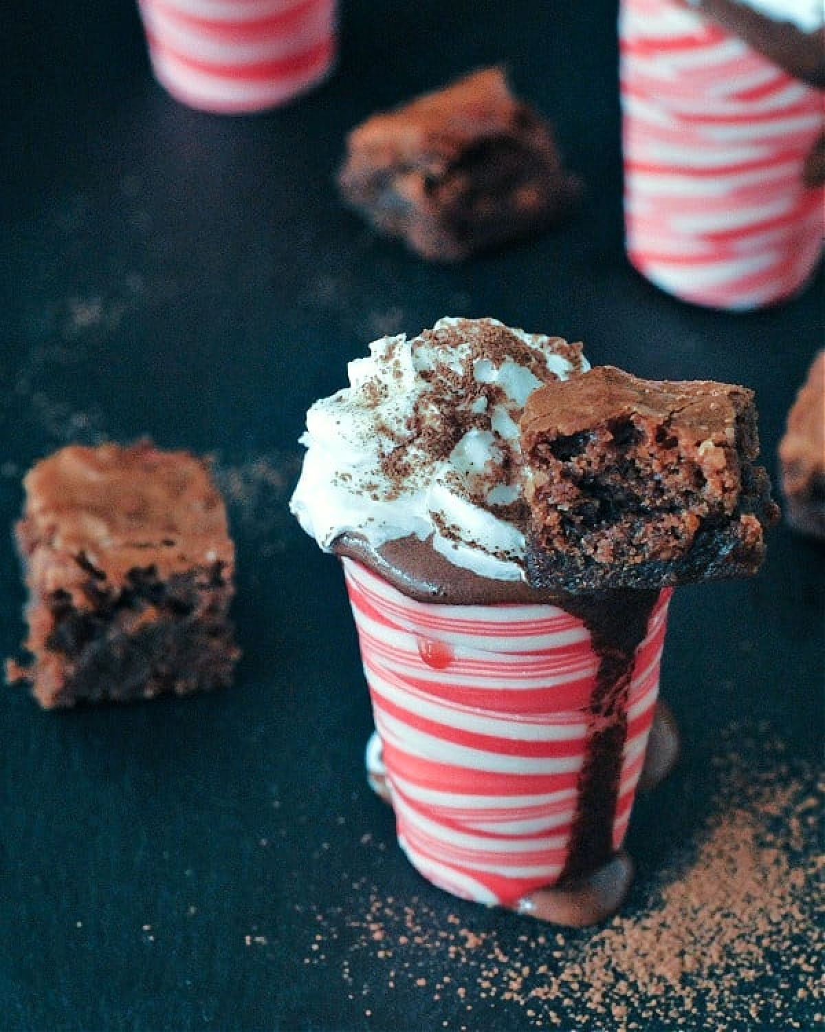 Hot chocolate peppermint shots: hot chocolate in an edible peppermint candy shot glass, topped with whip cream and a small brownie square.