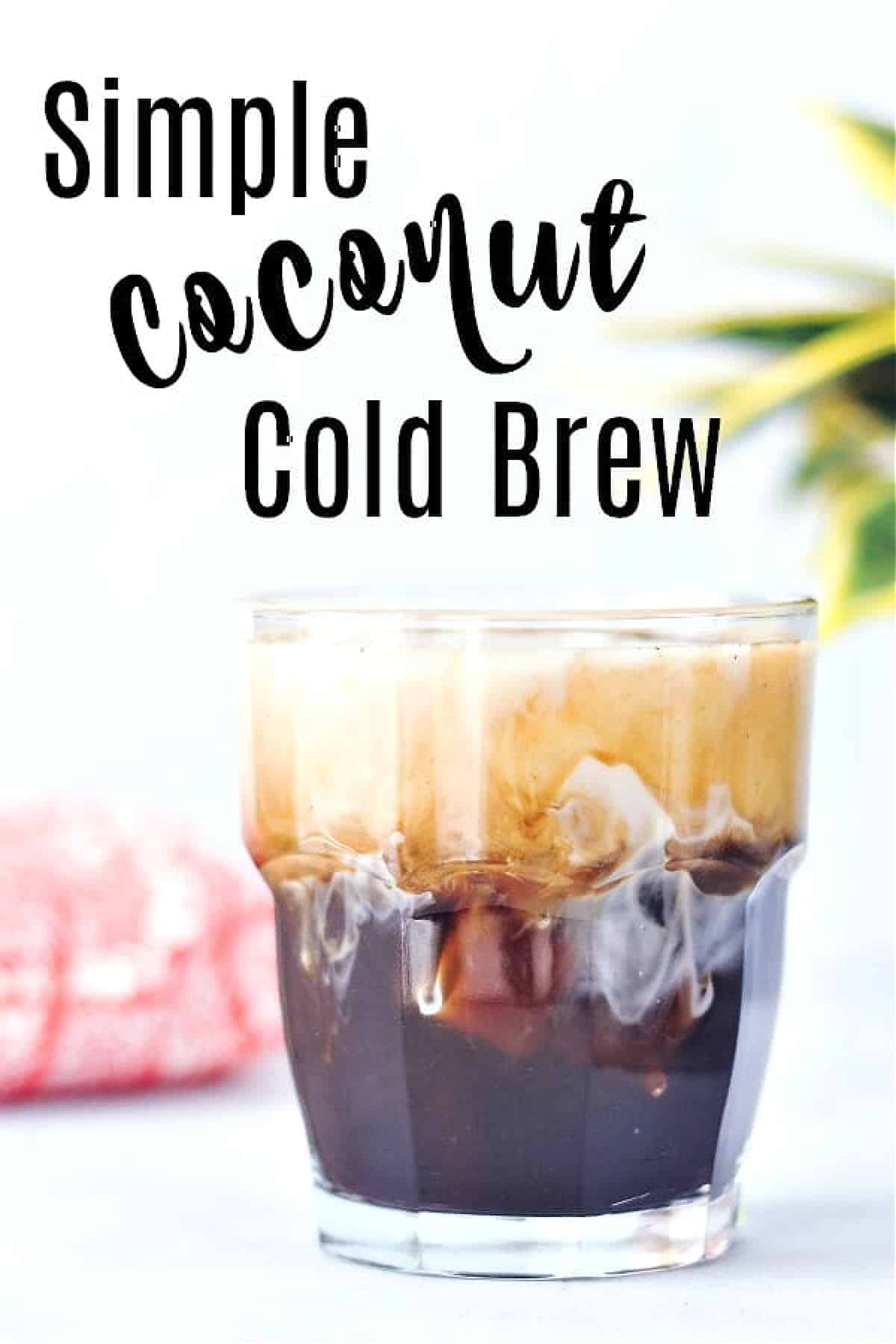 Coconut cold brew in a glass over ice, with coconut milk on top.