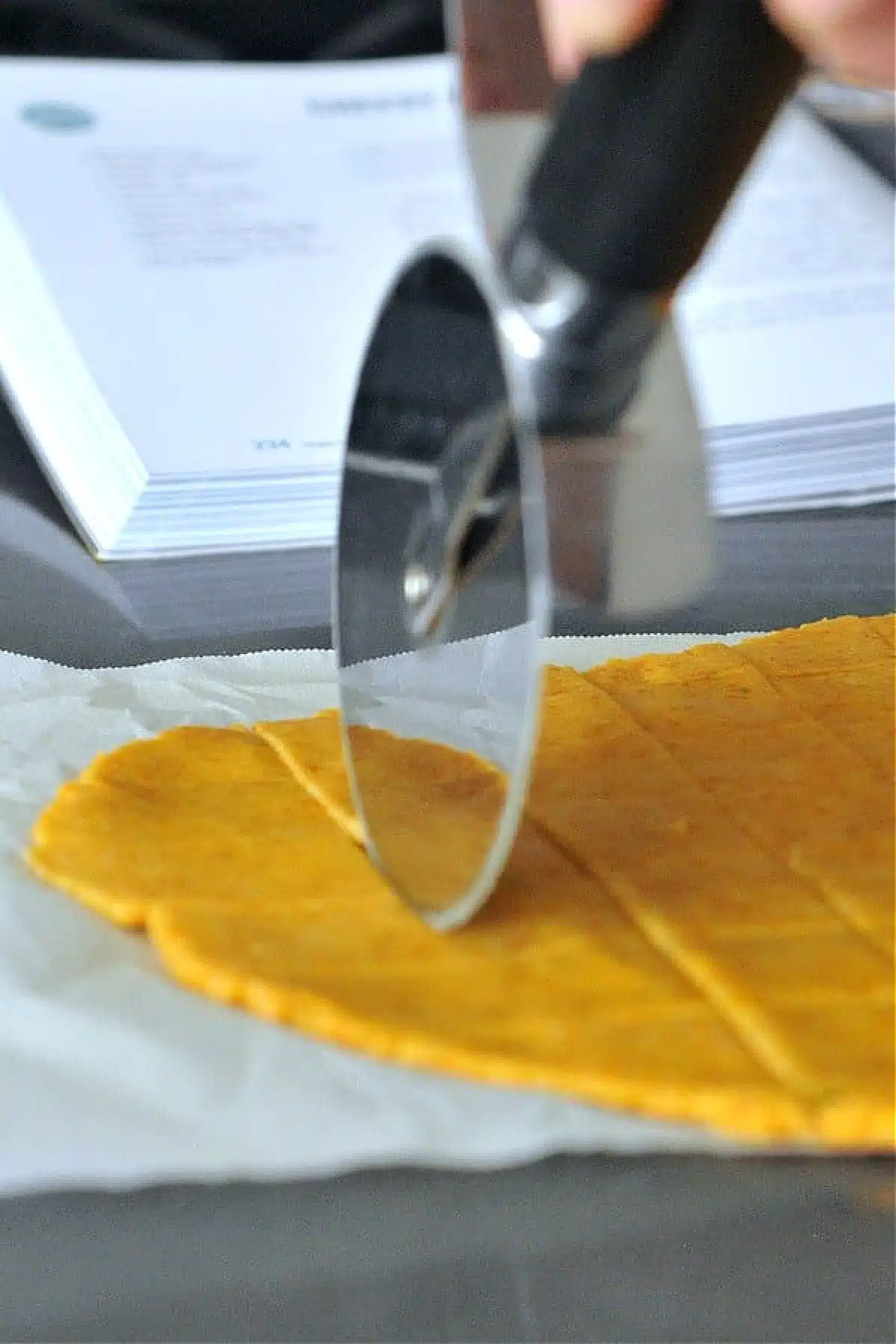 Cutting cracker dough with a pizza roller.