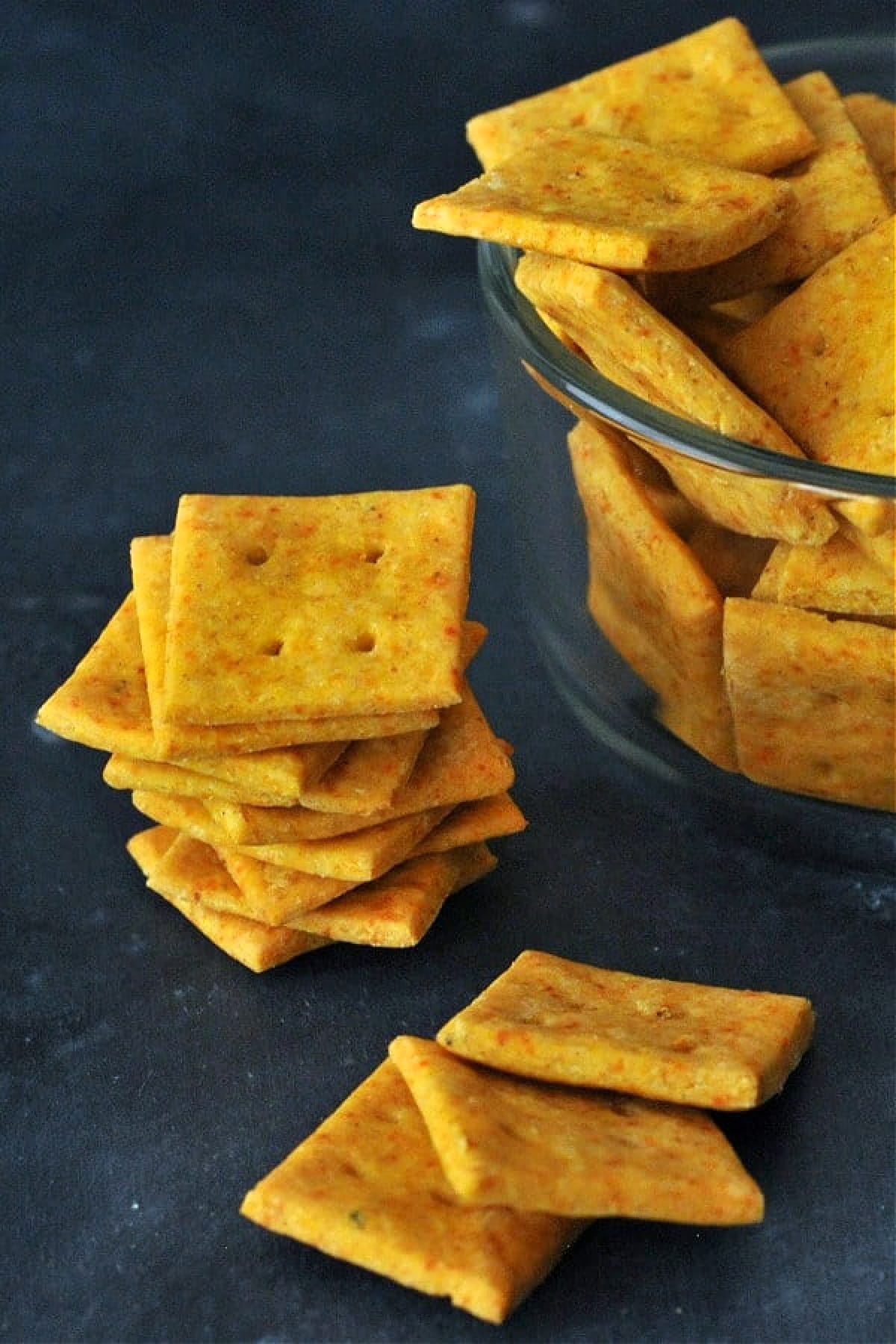 A stack and a bowl of gluten free cheese crackers.