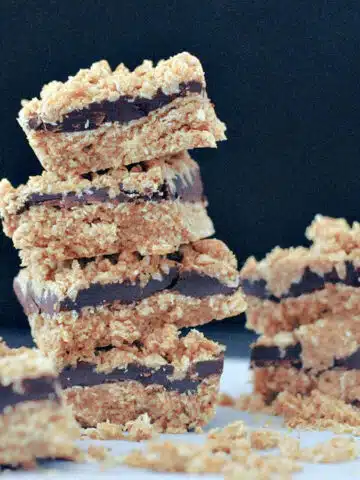 Chocolate no bake bars stacked four high and two high against a black background.