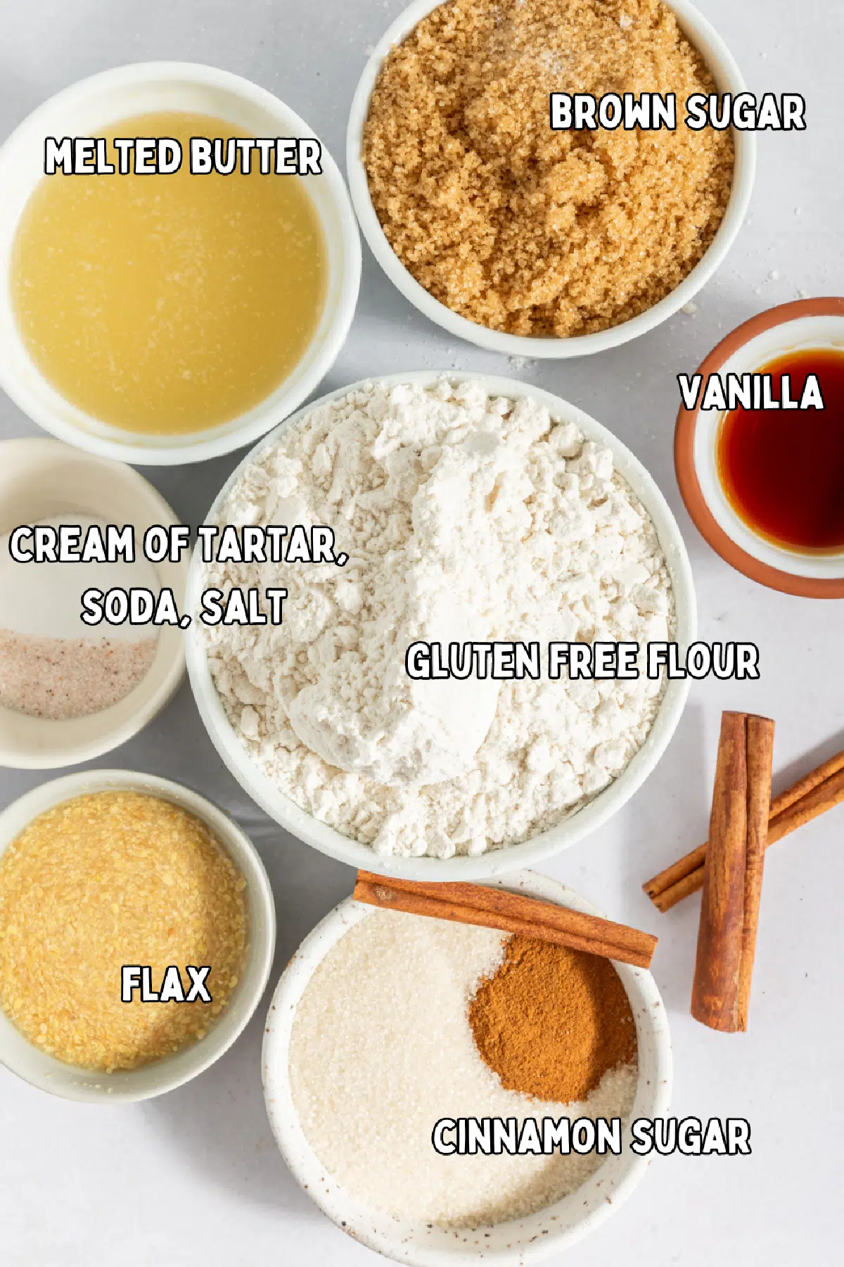 Small bowls of ingredients to make snickerdoodle blondies: brown sugar, melted butter, vanilla, flour, cream of tartar, baking soda, salt, flax and water, cinnamon and sugar.