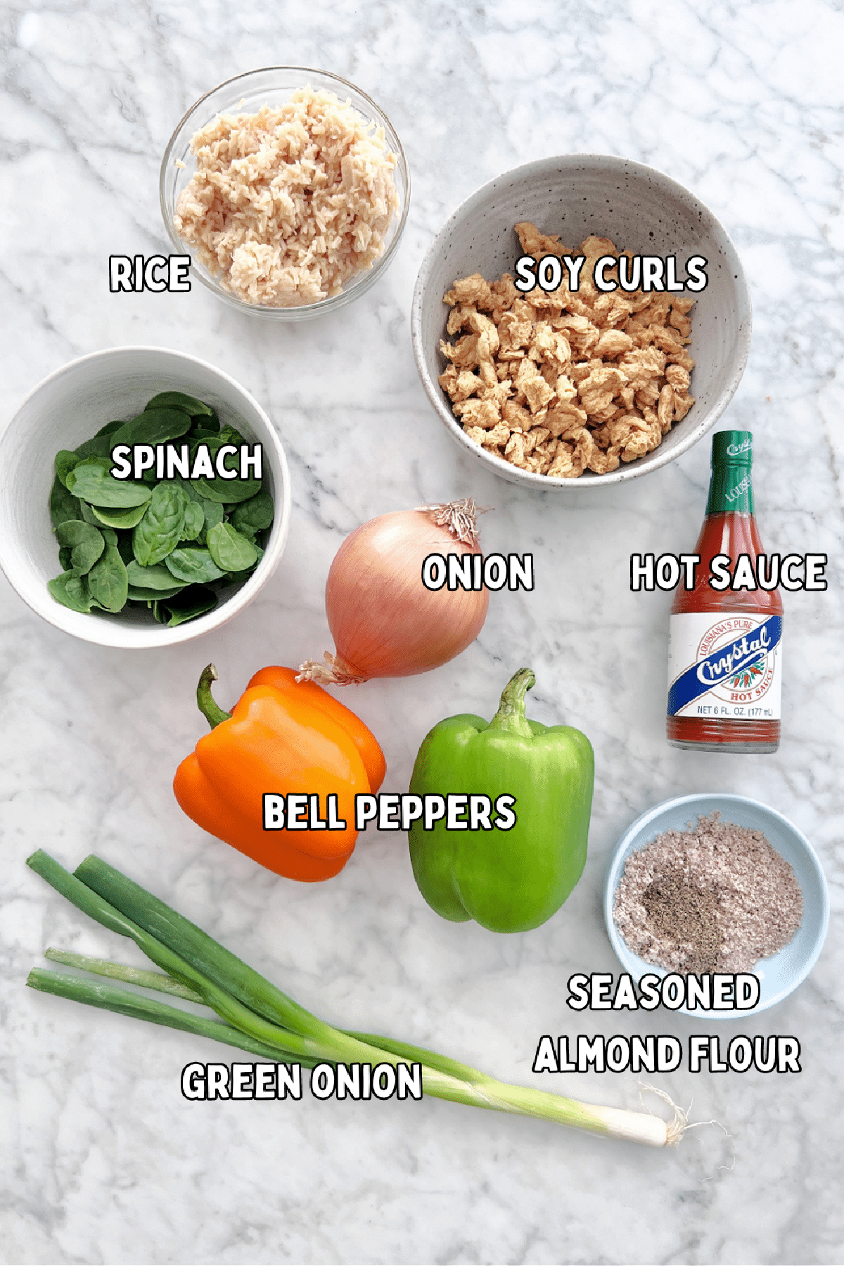 Bowls of ingredients for vegan buffalo chicken stuffed peppers: rice, soy curls, spinach, onion, hot sauce, bell peppers, green onion, and seasoned almond flour.