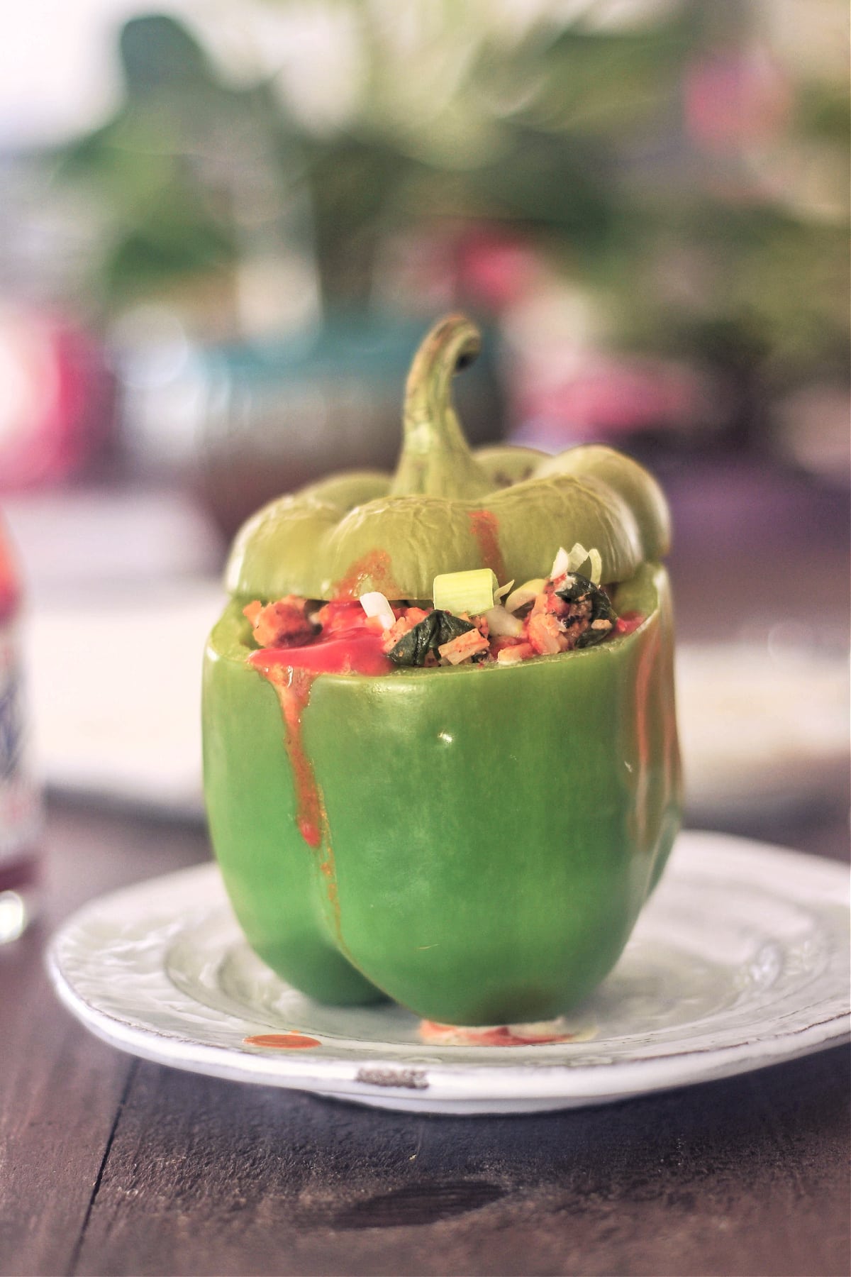A green bell pepper stuffed with vegan chicken and veggie filling.