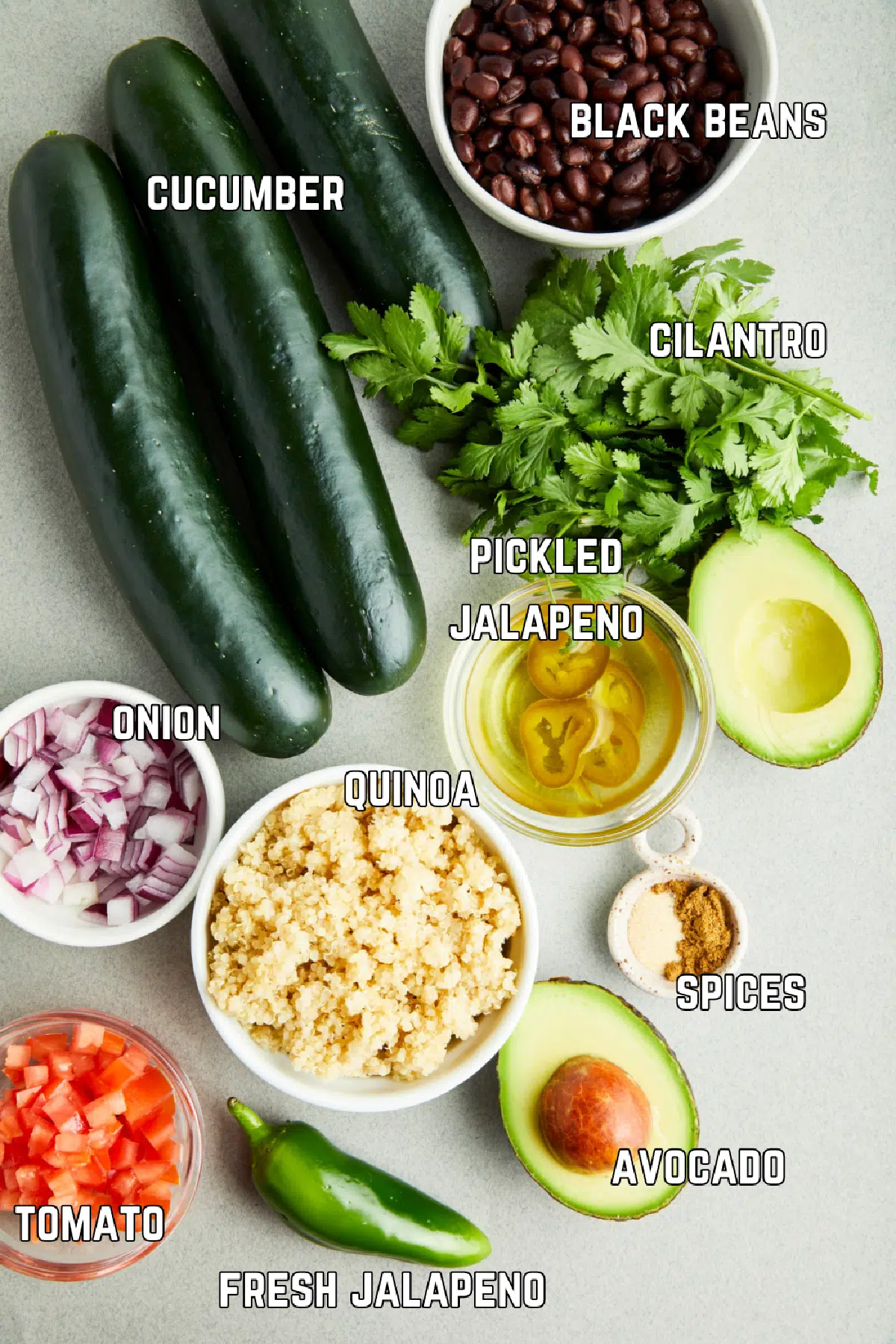 Ingredients to make tex mex cucumber boats: cucumbers, black beans, fresh herbs, pickled and fresh jalapeno, avocado, spices, quinoa, onion, and tomato.